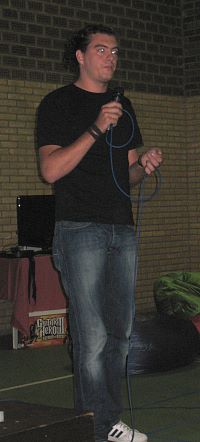 A student explaining his team's concept. Photo of student with microphone.
